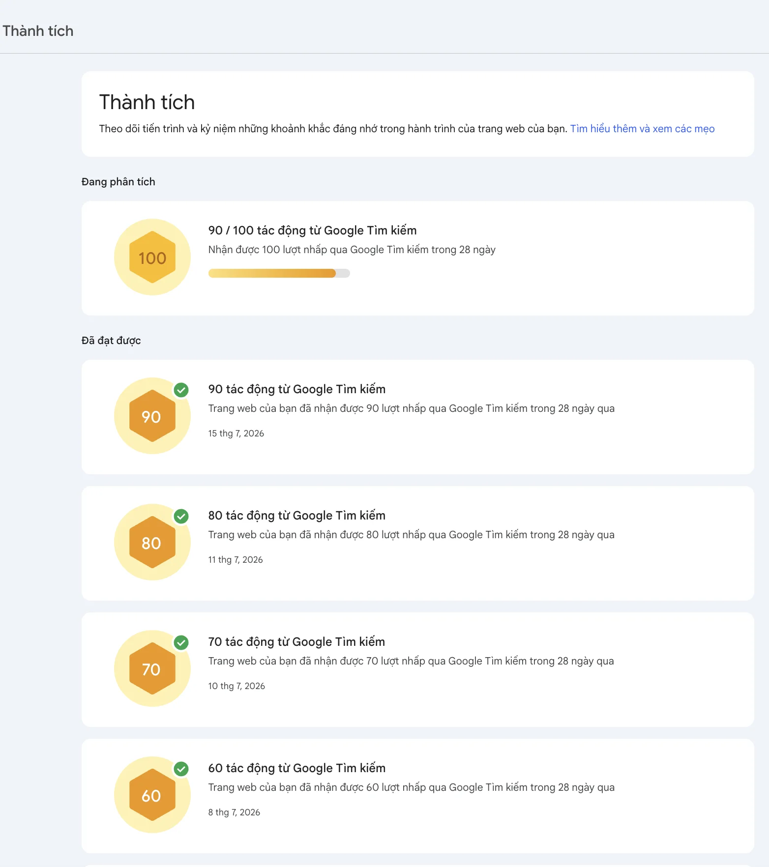 Google Search Console's achievements screen in Vietnamese: orange hexagon milestone badges for 60, 70, 80 and 90 clicks from Google Search, each ticked green and dated 8, 10, 11 and 15 July 2026, with the 100-click badge in progress at 90 of 100